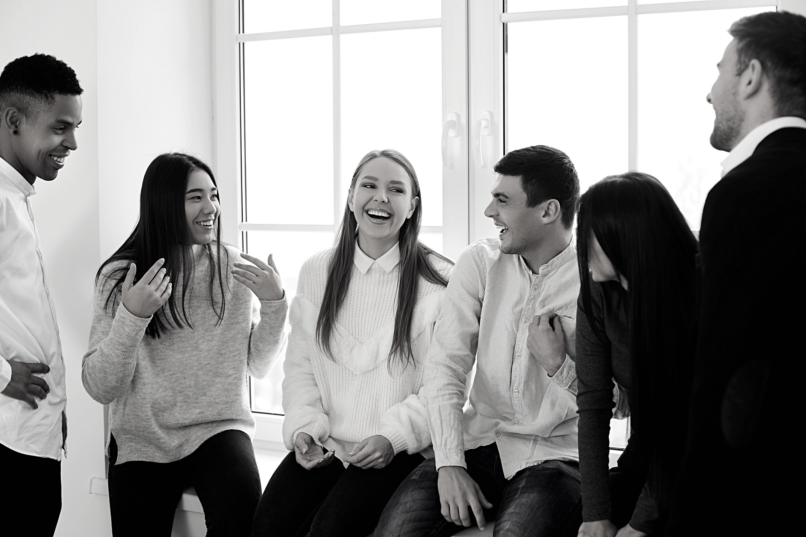 Group of Happy Young Coworkers, Students or Friends Talking about Funny Stuff and Laughing